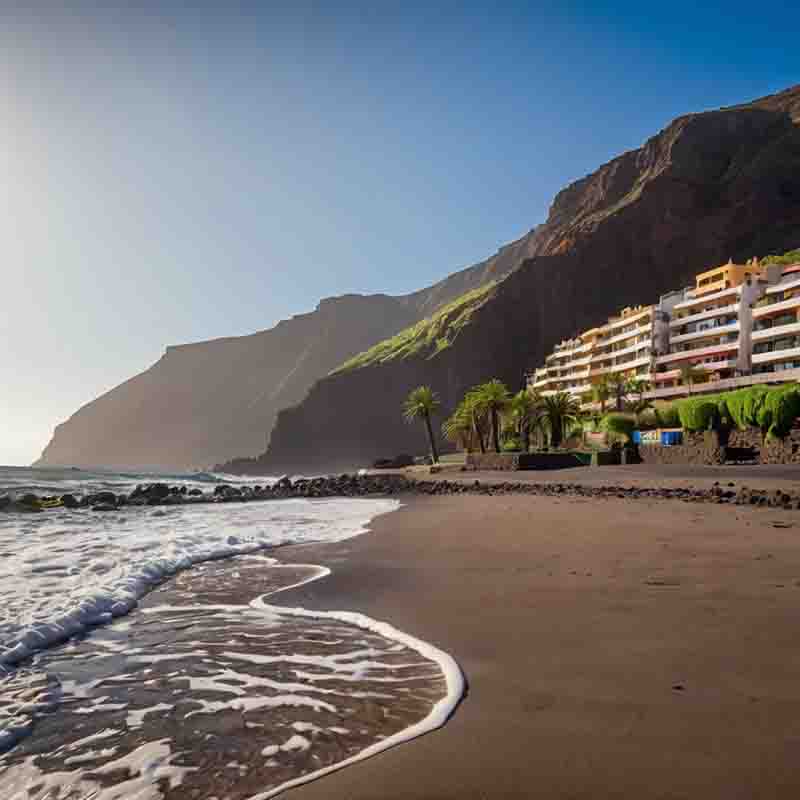 La Gomera Strand mit einem Hotel am Ufer und einem Berg im Hintergrund.